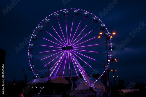Violet ferris wheel illuminated at night