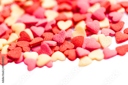 Valentines Day background with hearts on white with copyspace. The concept of Valentines Day Card. Baking decorations in heart shape - Sugar sprinkles
