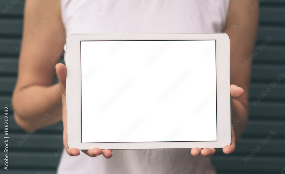 Close-up of female hands showing and using modern digital tablet with blank screen for your text message, mock-up of template tablet pc, hipster girl sitting at the park with technology outside. Close-up of female hands showing and using modern digital tablet with blank screen for your text message, mock-up of template tablet pc, hipster girl sitting at the park with technology outside.