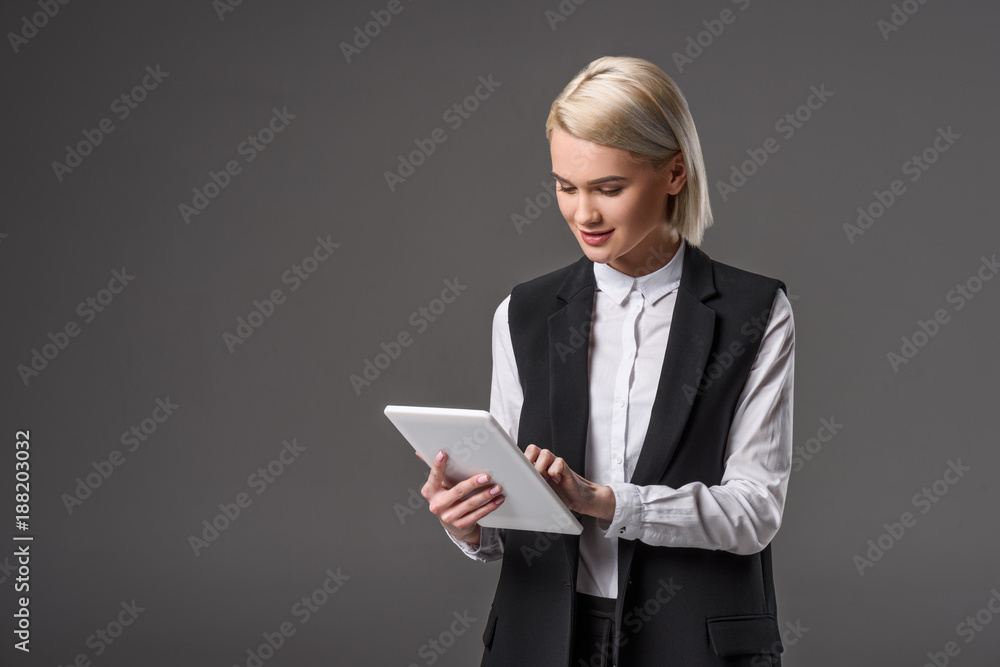 portrait of young woman using tablet isolated on grey portrait of young woman using tablet isolated on grey