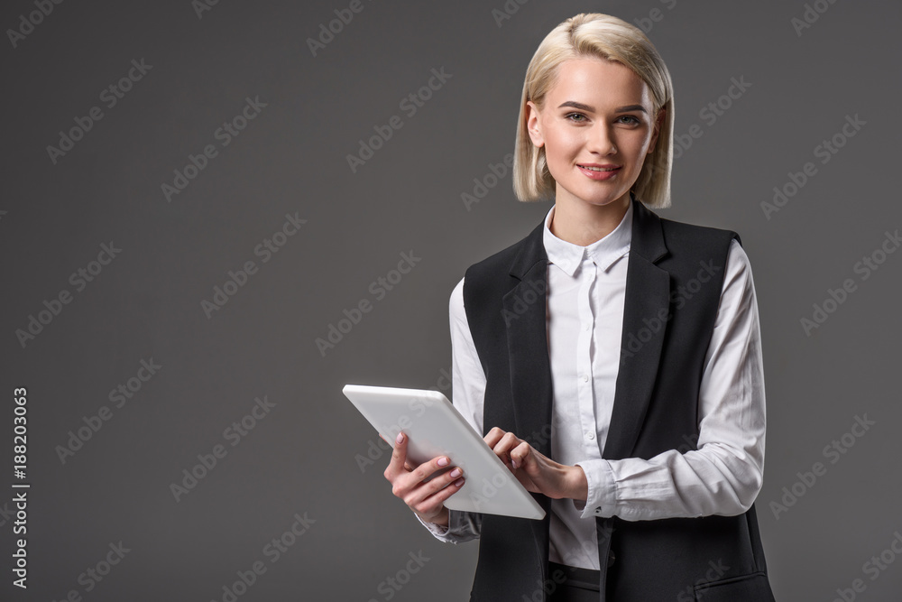 portrait of young woman using tablet isolated on grey portrait of young woman using tablet isolated on grey