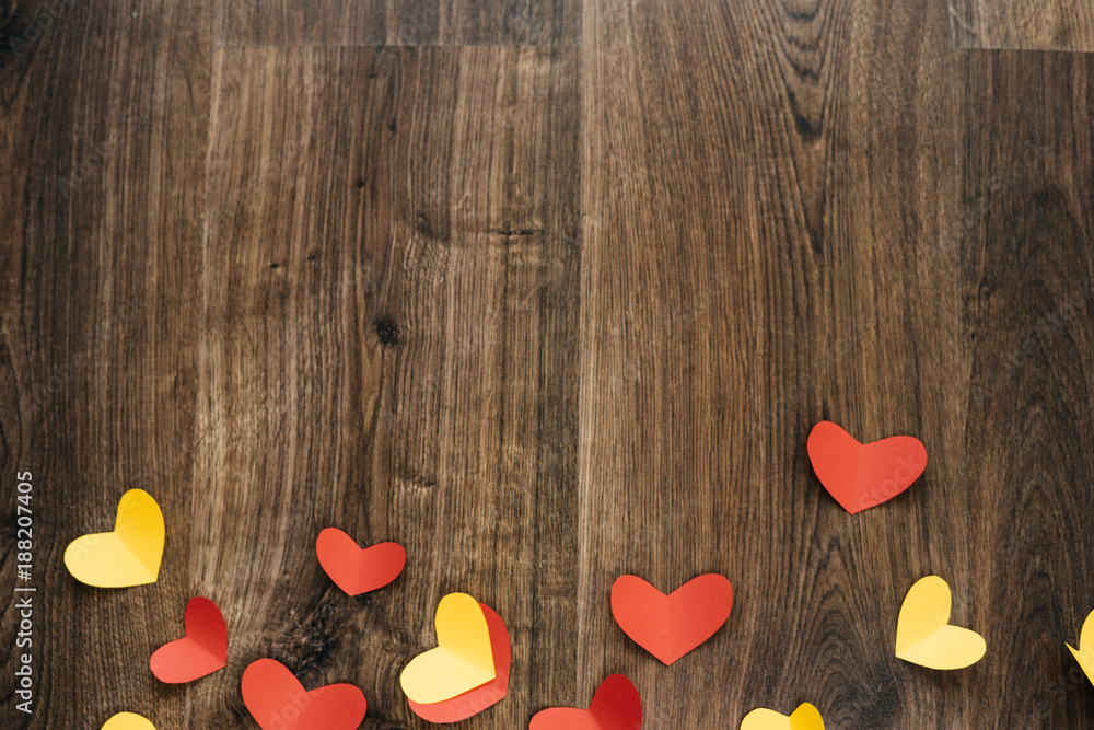 Fototapeta premium Valentine 's Day background, red and yellow hearts on wood texture