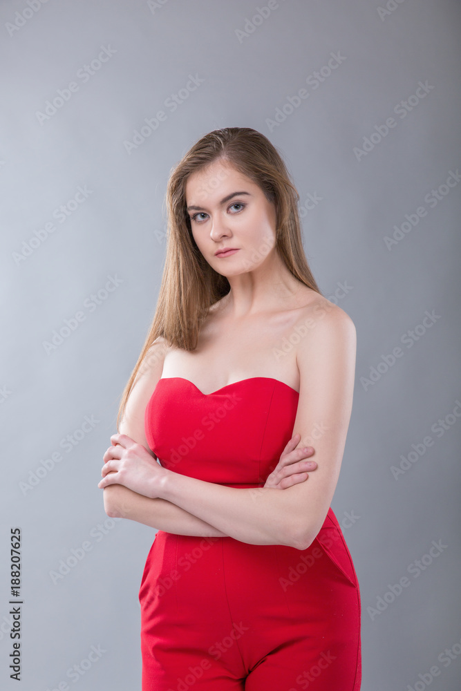 Young beautiful plus size model wearing in red costume, xl woman on gray studio background Young beautiful plus size model wearing in red costume, xl woman on gray studio background