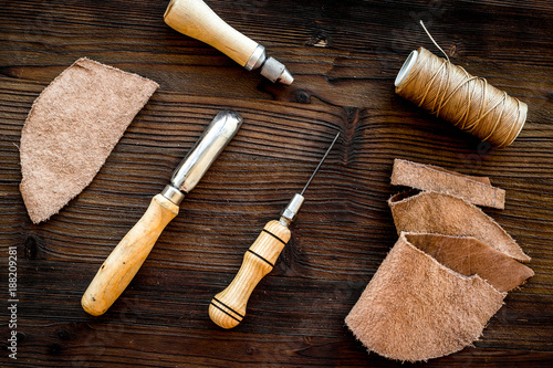Leather craft accessories. Tools and matherials on dark wooden b