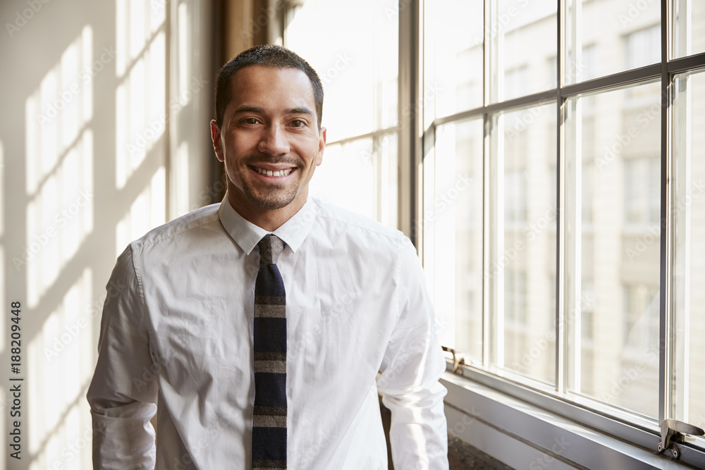 Fototapeta premium Young Hispanic businessman smiling to camera, close up
