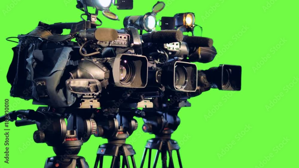 A side view on three professional video cameras. A side view on three professional video cameras.