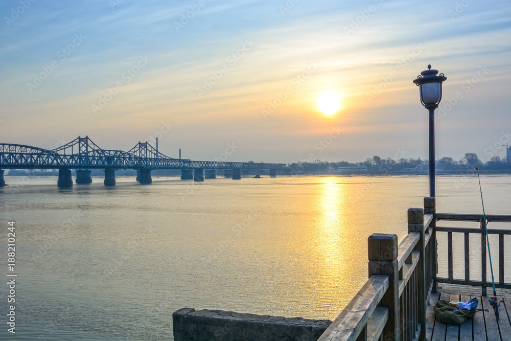 Yalu River Bridge and Yalu River Scenic Areas at morning. In the distance is North Korea. Located in Dandong, Liaoning, China.