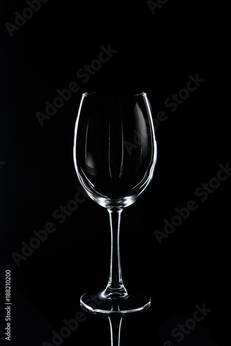 one wineglass on black reflecting tabletop
