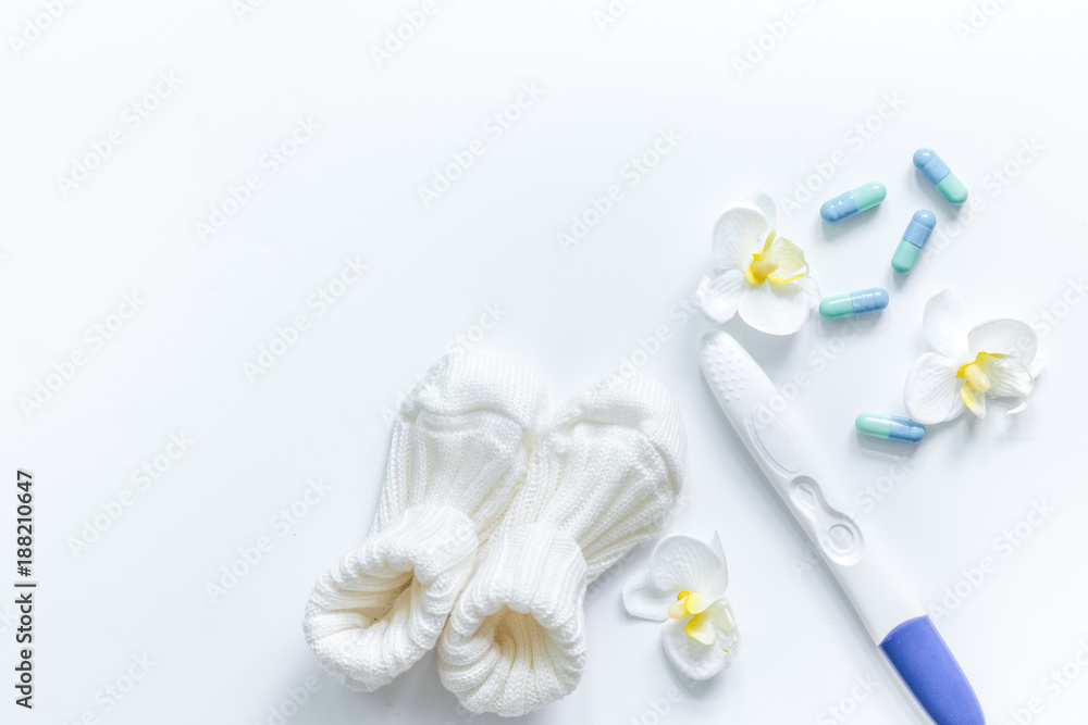 Pregnancy test and booties on white background top view copyspac Pregnancy test and booties on white background top view copyspac