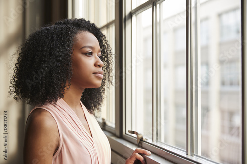 Photography Young black businesswoman looking out of window