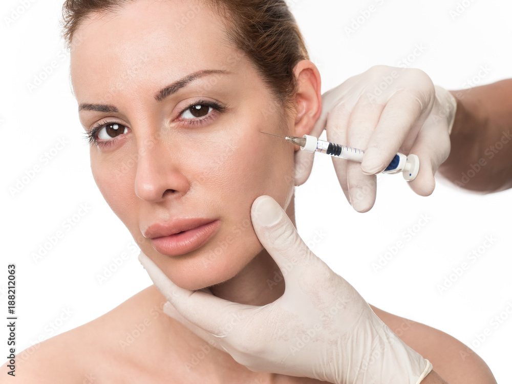 Closeup of beautiful woman receiving hyaluronic acid treatment. Isolated over white background. Closeup of beautiful woman receiving hyaluronic acid treatment. Isolated over white background.