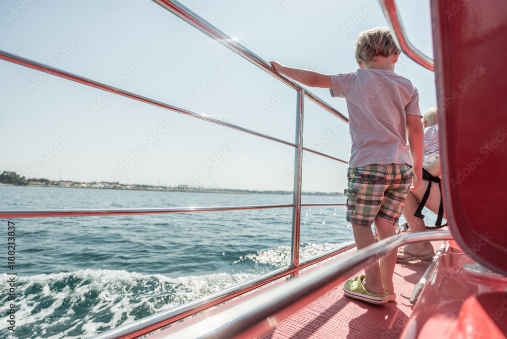 Boy standing on boat deck on sunny day