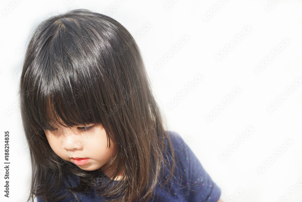 Little asian girl angry and sad looking down on white background. Little asian girl angry and sad looking down on white background.