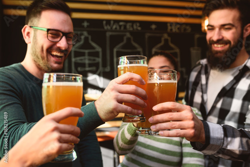 Sticker Smiling young people drinking craft beer in pub