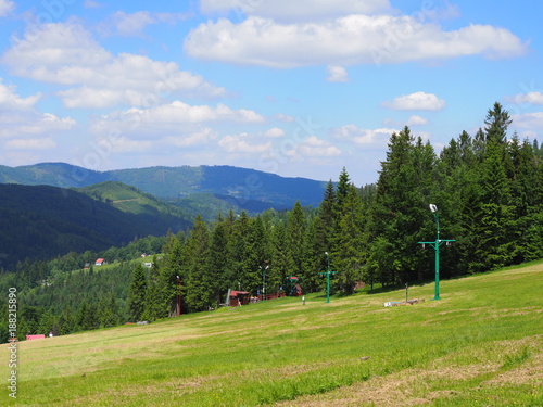 Countryside landscape of grassy field and forest at Beskid Mountains range on Bialy Krzyz in POLAND