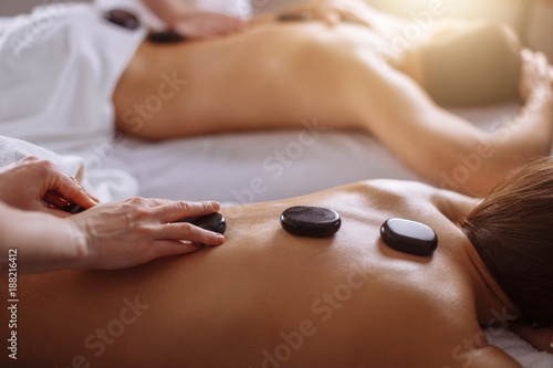 Фотография couple in spa salon having hot stone massage