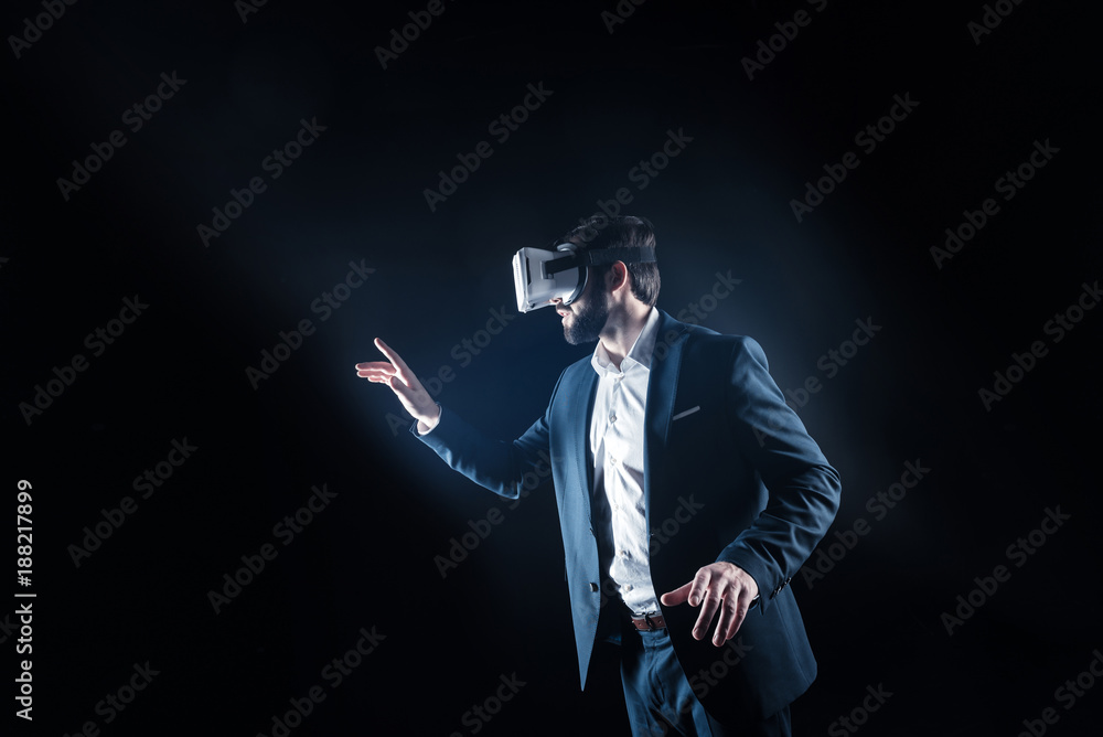 Professional device. Delighted nice handsome man holding up his hand and looking in front of him while wearing 3d glasses Professional device. Delighted nice handsome man holding up his hand and looking in front of him while wearing 3d glasses