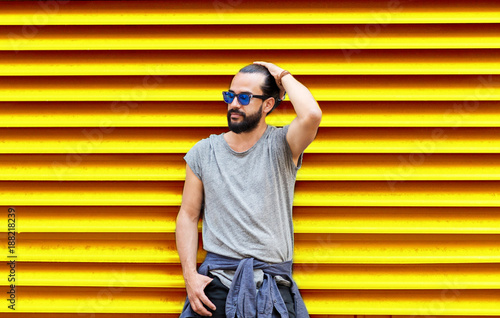 man in sunglasses over ribbed yellow background