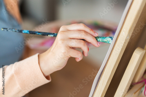 hand of artist with brush painting at art studio
