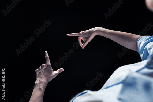 Virtual object. Close up of female hands holding a virtual object against black background