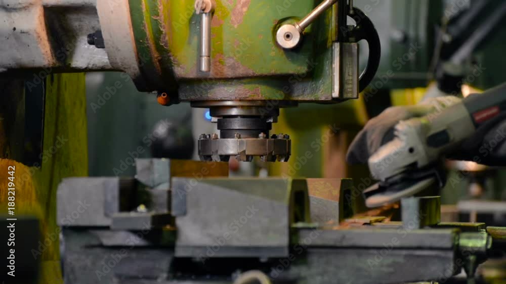 The worker makes a cleaning of the sharp edges of the manufactured part. The worker makes a cleaning of the sharp edges of the manufactured part.
