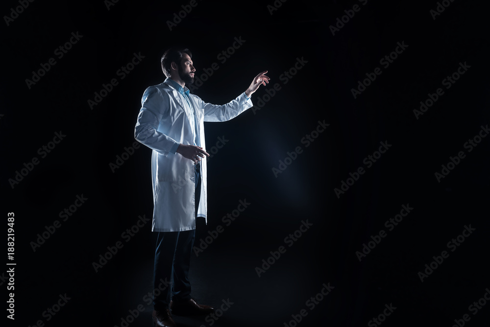 Professional lab. Serious nice smart scientist standing in the lab and using smart technologies while working