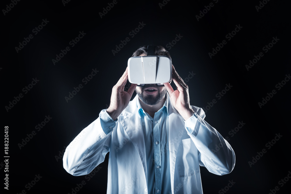 This is amazing. Serious smart nice scientist holding 3d glasses and looking in front of him while being impressed by modern technology This is amazing. Serious smart nice scientist holding 3d glasses and looking in front of him while being impressed by modern technology