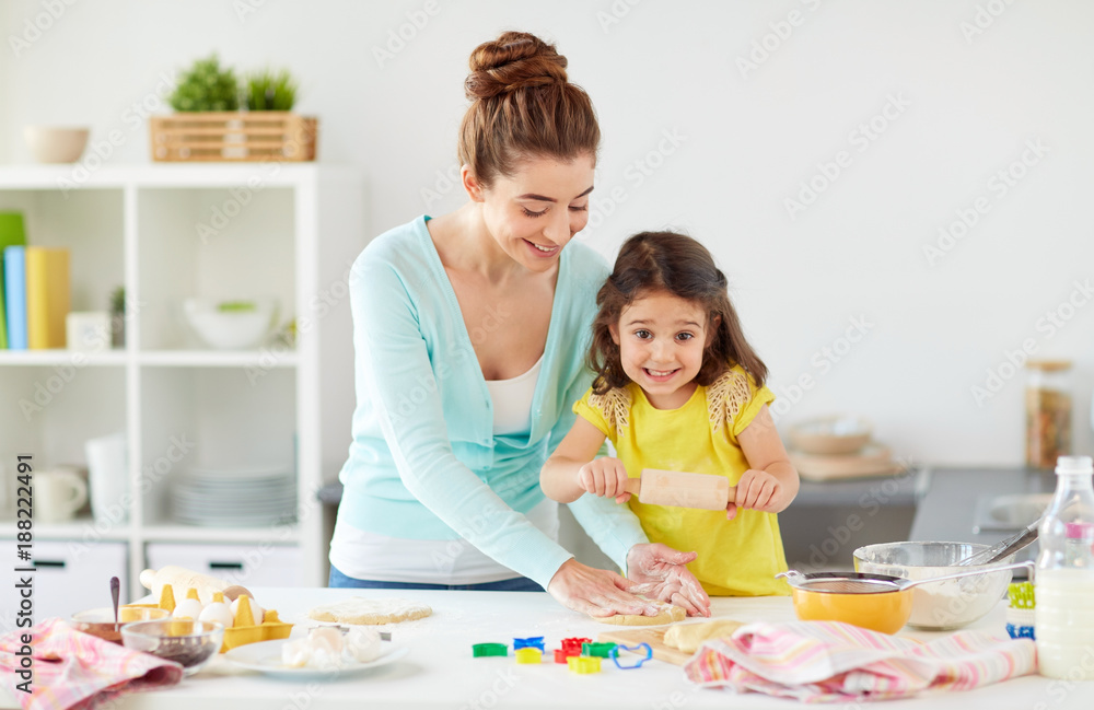 Fototapeta premium happy mother and daughter making cookies at home