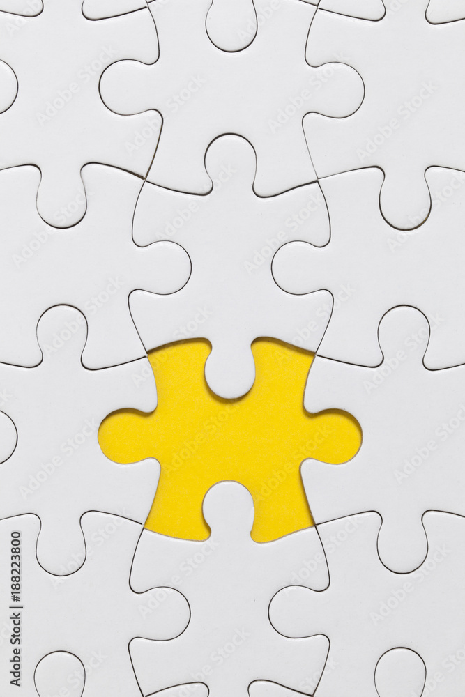 White jigsaw puzzle pieces on a yellow background. Business solution concept White jigsaw puzzle pieces on a yellow background. Business solution concept
