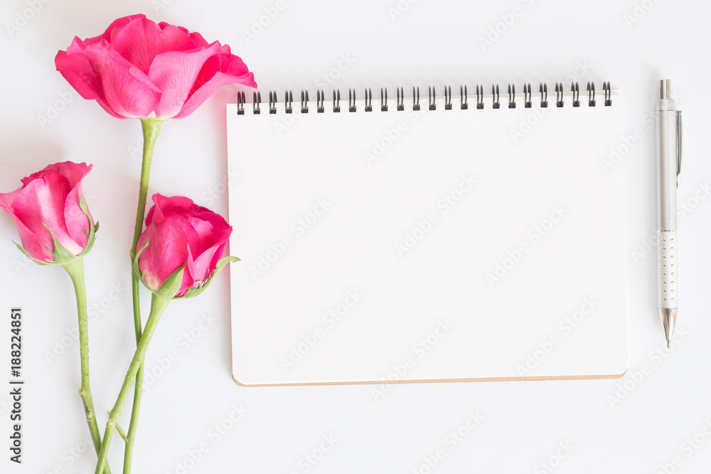 Fototapeta premium Blank notebook with pink roses and pen on white background,Flat lay photo of a notebook for your message,Valentine's Day concept