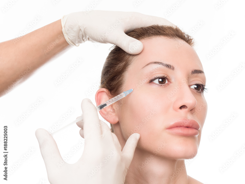 Hands of cosmetologist injecting woman's face Hands of cosmetologist injecting woman's face