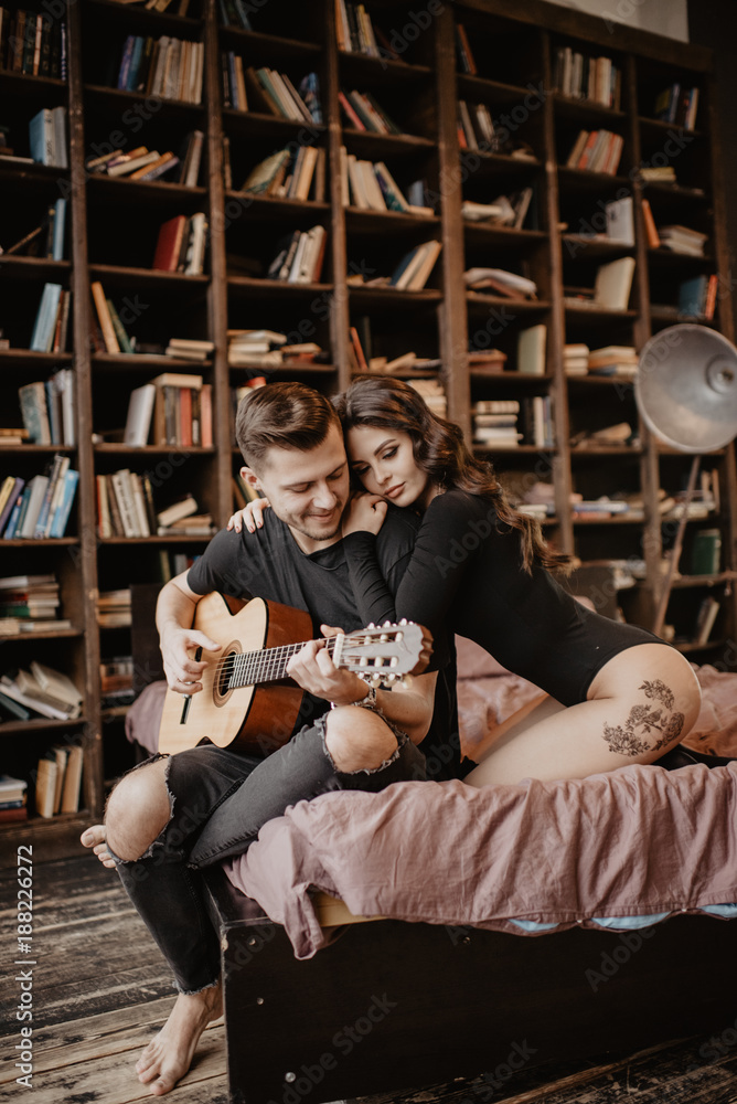 beautiful sexy girl and her boyfriend playing guitar
