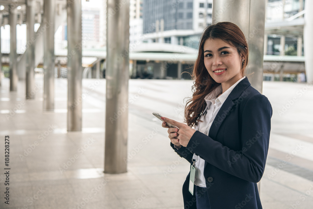 Fototapeta premium Asian business woman is holding and using phone.