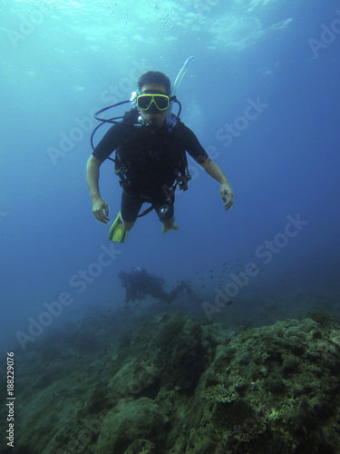 Thailand, Pang-nga, Kho Lak, 3rd Jan'18. Kho Na Yak. Student for diving open water course with diving gear (equipment) practicing diving in the deep blue sea surrounding by brown corals. Editorial.