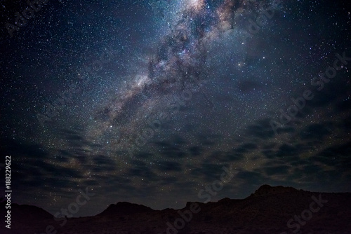 Milky Way arch, stars in the sky, the Namib desert in Namibia, Africa. Some scenic clouds.