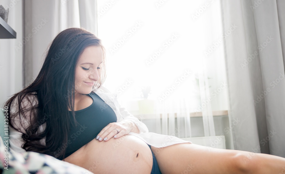 Relaxed smiling pregnant woman lying on sofa resting at home Relaxed smiling pregnant woman lying on sofa resting at home