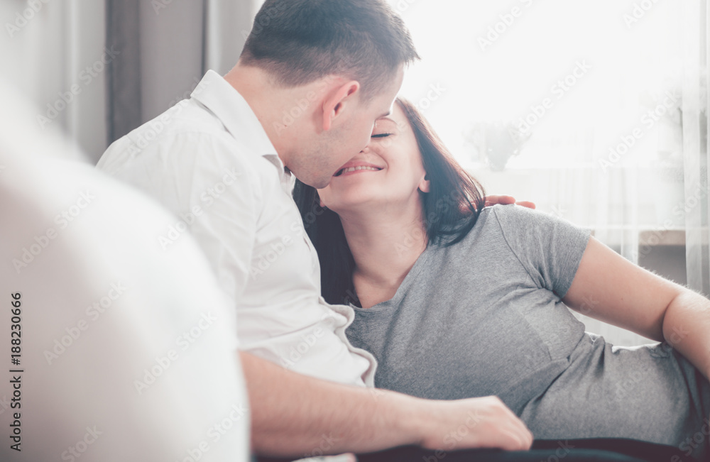 Cheerful pregnant couple relaxing at home and enjoying pregnancy time Cheerful pregnant couple relaxing at home and enjoying pregnancy time