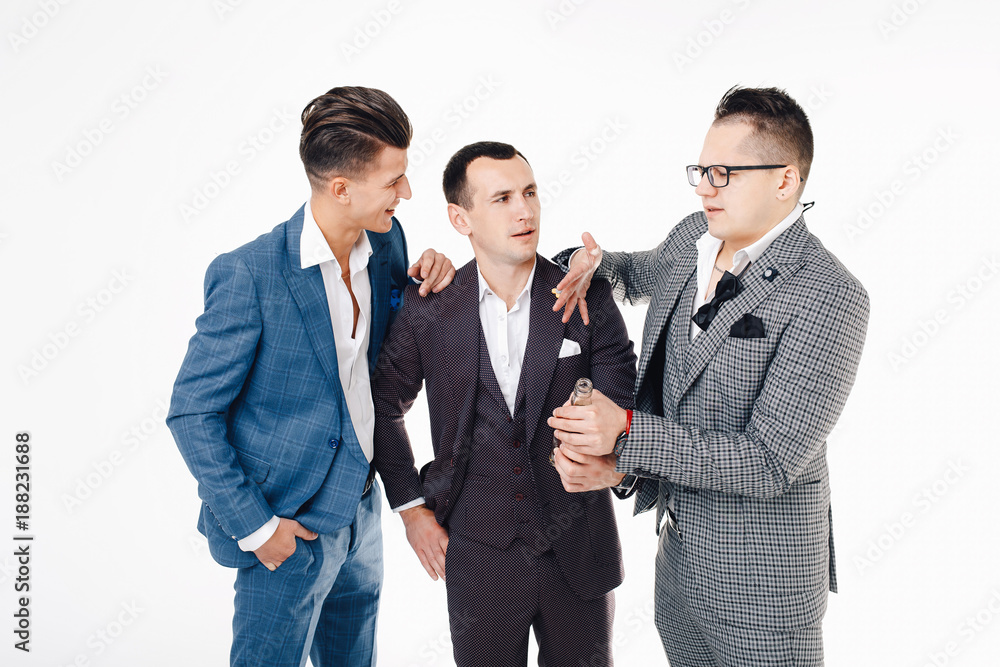 Group of handsome elegant young men in suits talking and laughing. Stag-party concept