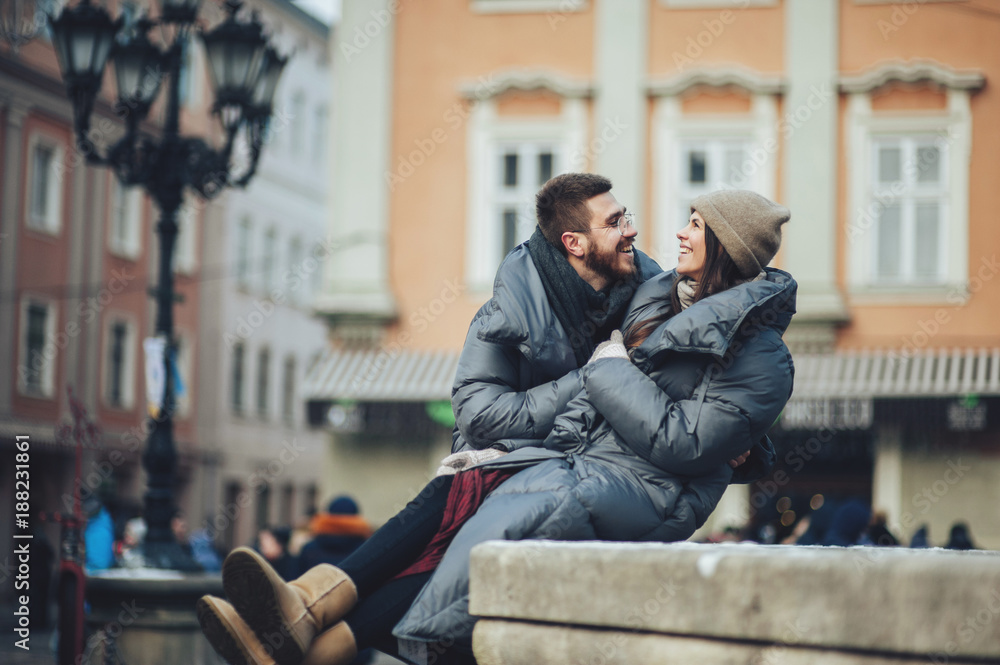 Classy groom and his gorgeous bride pose outside in winter coats 