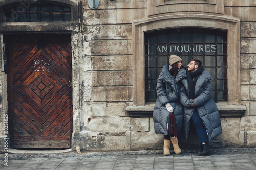 Classy groom and his gorgeous bride pose outside in winter coats 