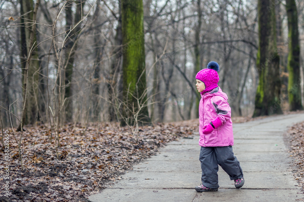 Little girl walking alone in a forest at autumn Little girl walking alone in a forest at autumn