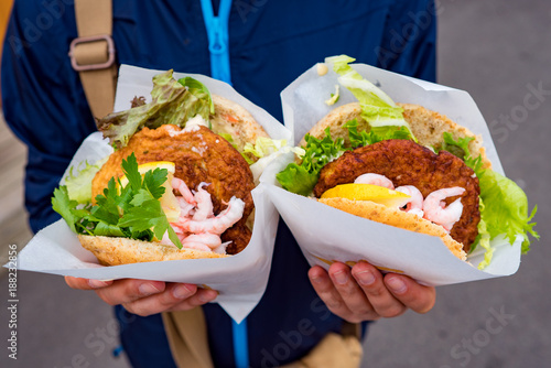 Fast street food seafood. Norway Lofoten Islands, fish cutlet with salad and grilled shrimp photo