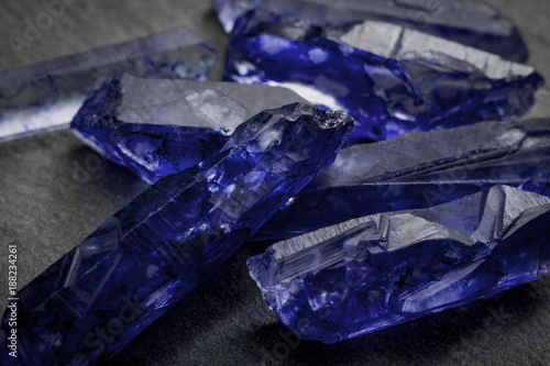 Sapphires and raw crystal gems concept with closeup of a bunch of blue uncut sapphire crystals photo
