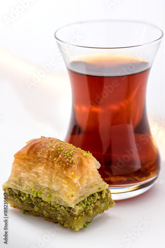 Baklava with pistachio and turkish cup of tea on a white background