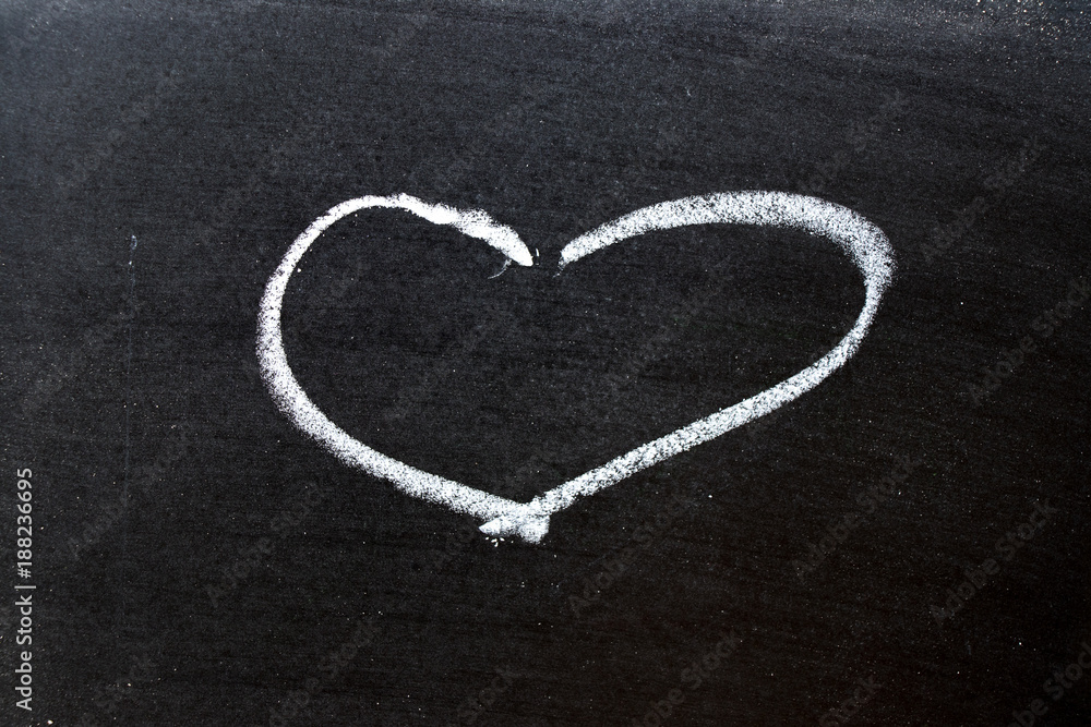 White coloe chalk drawing as heart shape on blackboard background with copy space