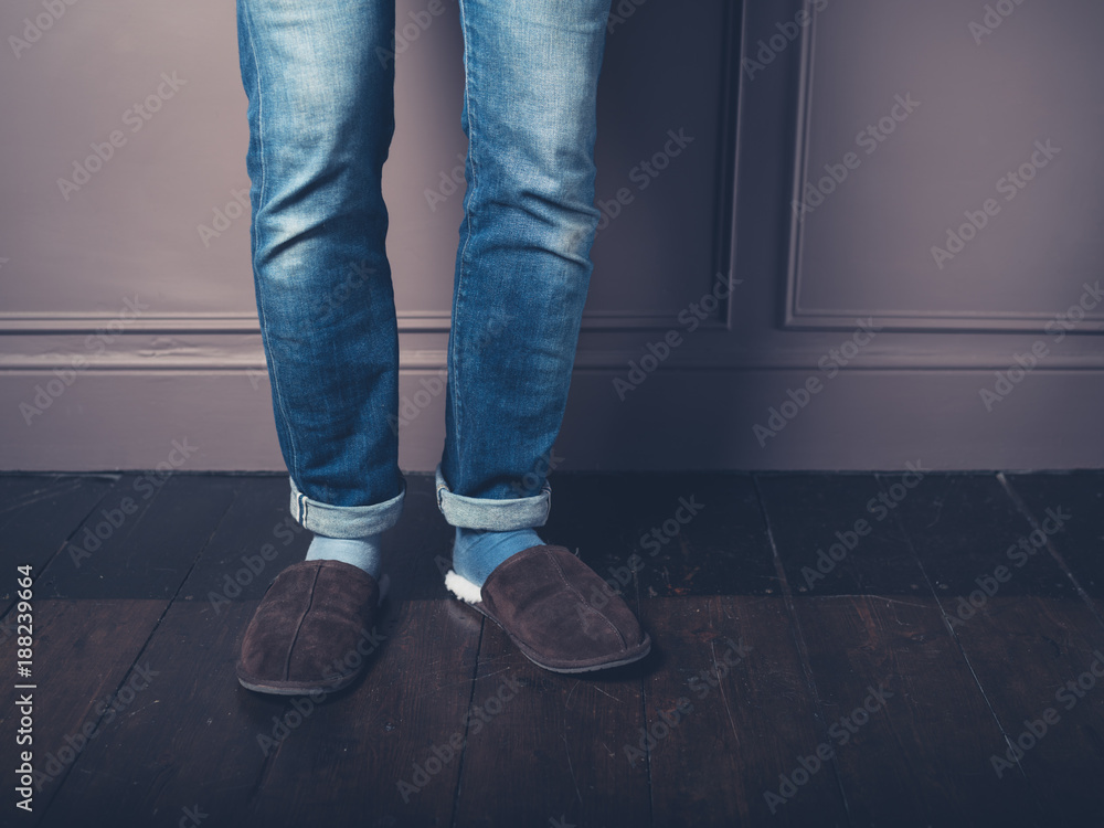 Young man with slippers on wooden floor Young man with slippers on wooden floor