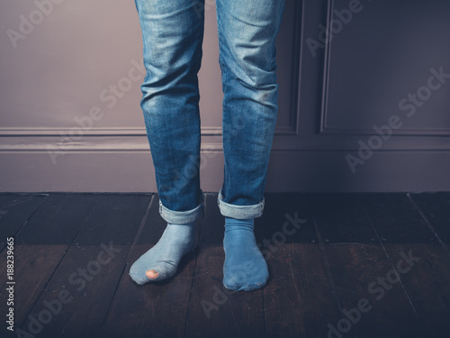 Man in worn socks on wooden floor