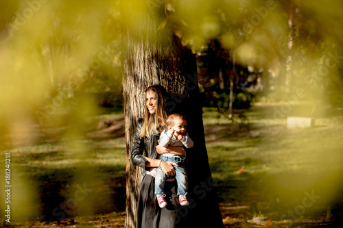 Young mother and baby boy in autumn park