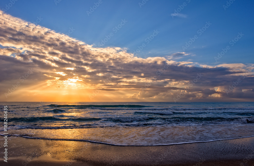A sunrise in the mediterranean sea with the sun in the background