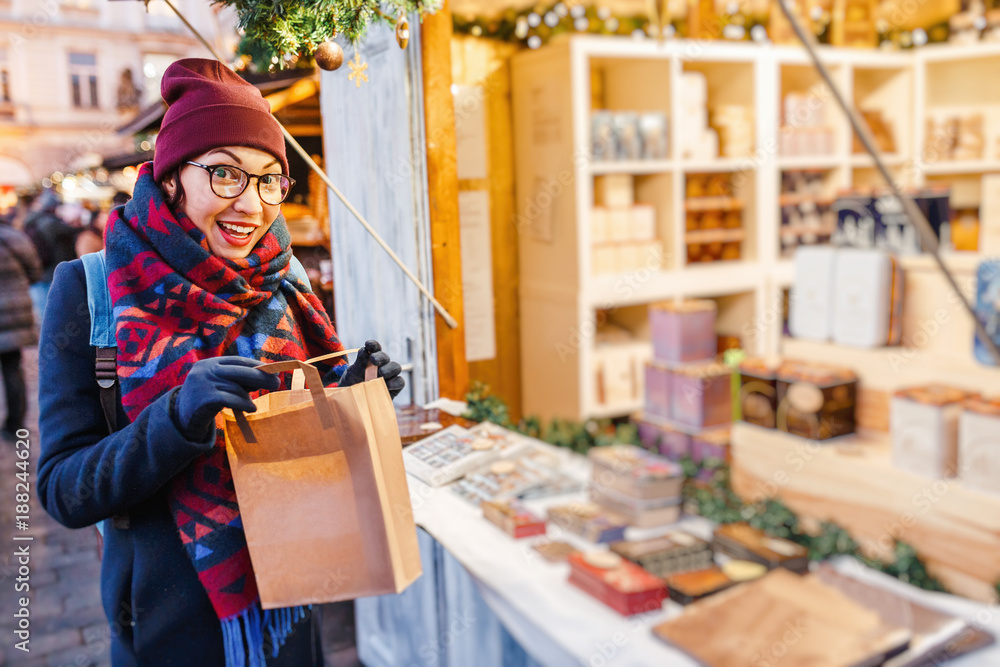 Stylish woman buys gifts and souvenirs at the Christmas market in Prague